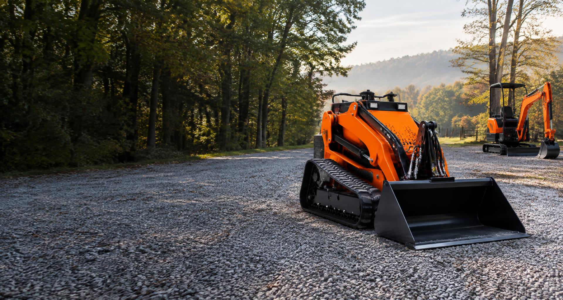 Orange mini skid steer and mini excavator on a gravel lane in the Virginia countryside